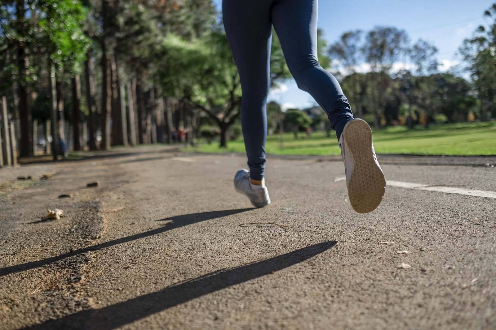 Runner jogging on a sunny park path